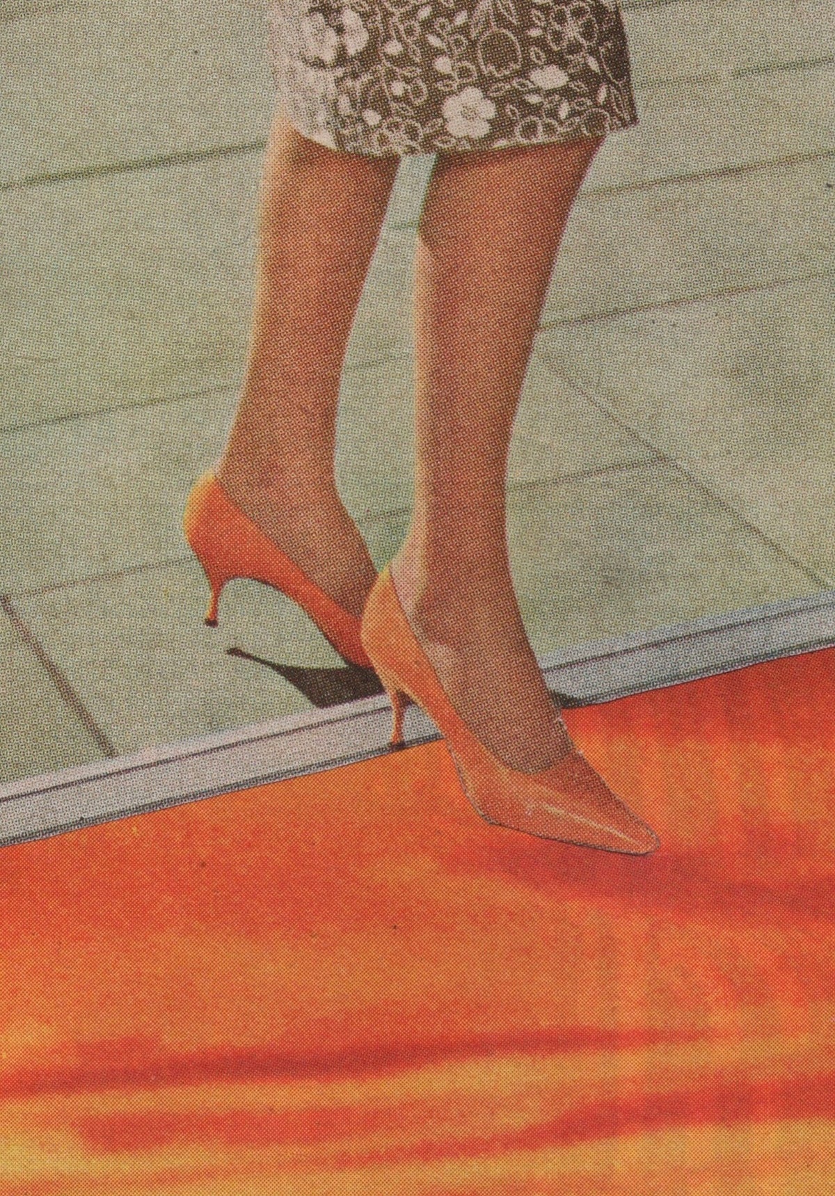 A close-up of a person's legs wearing pointed-toe high heels in a warm orange or peach tone, standing on a red-orange surface with a tiled floor in the background.