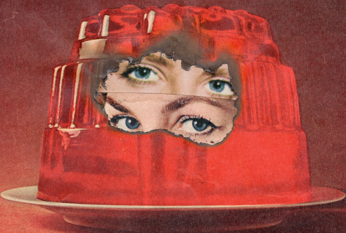 Red jelly mold with a face cutout on a red background